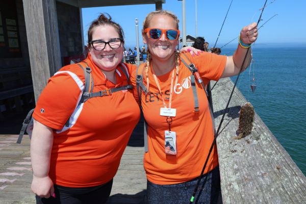 Two tour guides smiling with one fish on pier