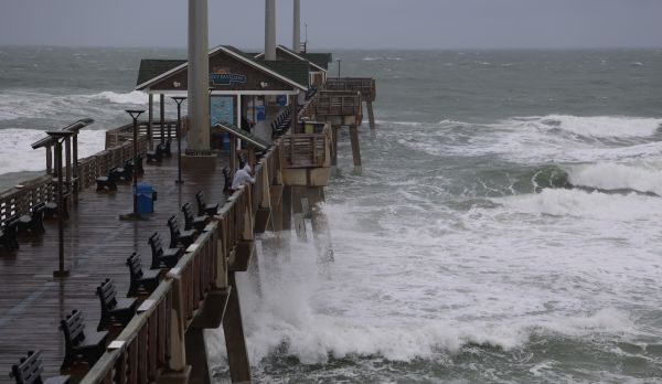 Dark skies and white-water ocean waves surround ocean fishing pier