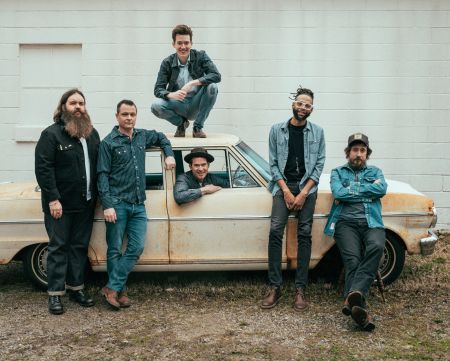 Old Crow Medicine Show band posing in front of antique car 