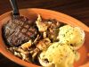 Steak with Poached Eggs on English Muffin topped with Hollandaise Sauce - served with grits, home fries or baked apples.